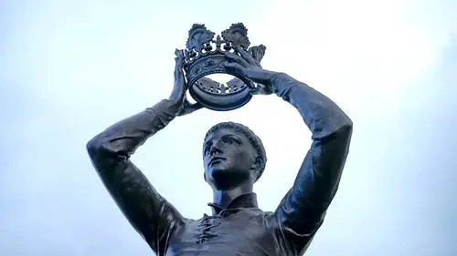 Statue of Man Holding Crown