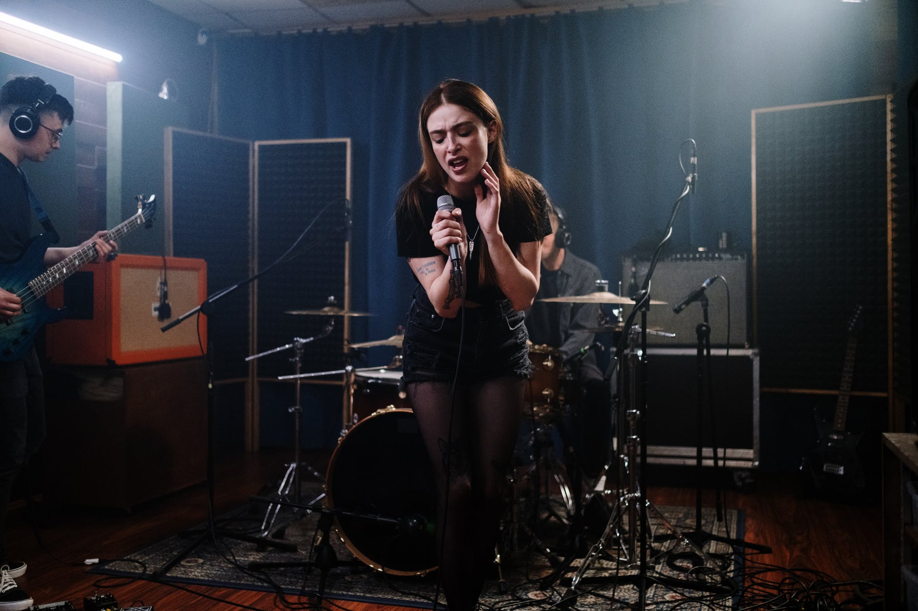 woman in black and white stripe shirt standing on black drum set